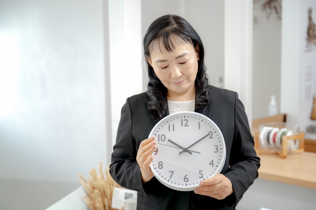 時計を持った女性が遅刻に悩まされている画像