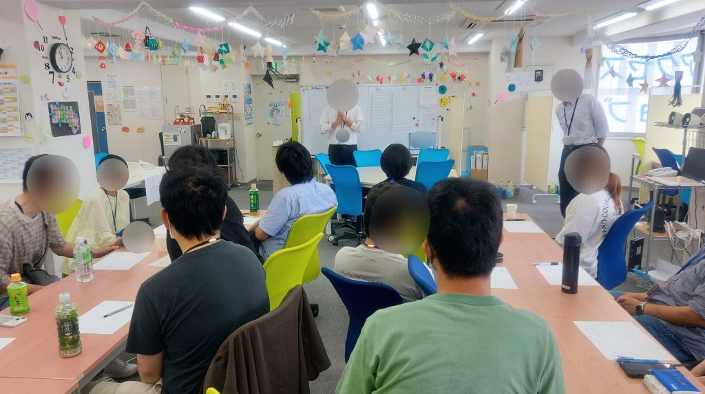 夏祭りを開催しました！～利用者と卒業生の交流会～終わりの言葉を聞いている様子の画像