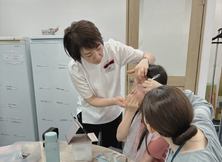 資生堂の方に手伝ってメイクをしている女性利用者さん