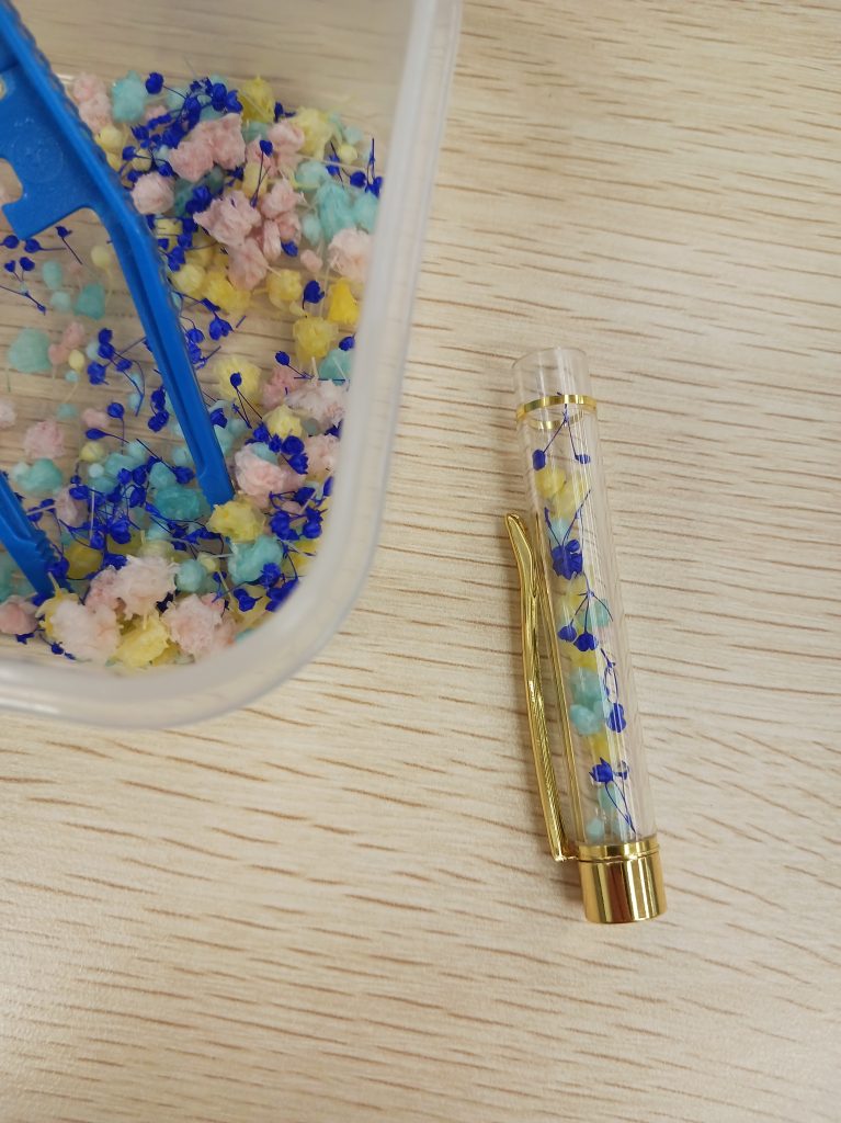 ボールペンの本体にピンセットでドライフラワーを入れます。