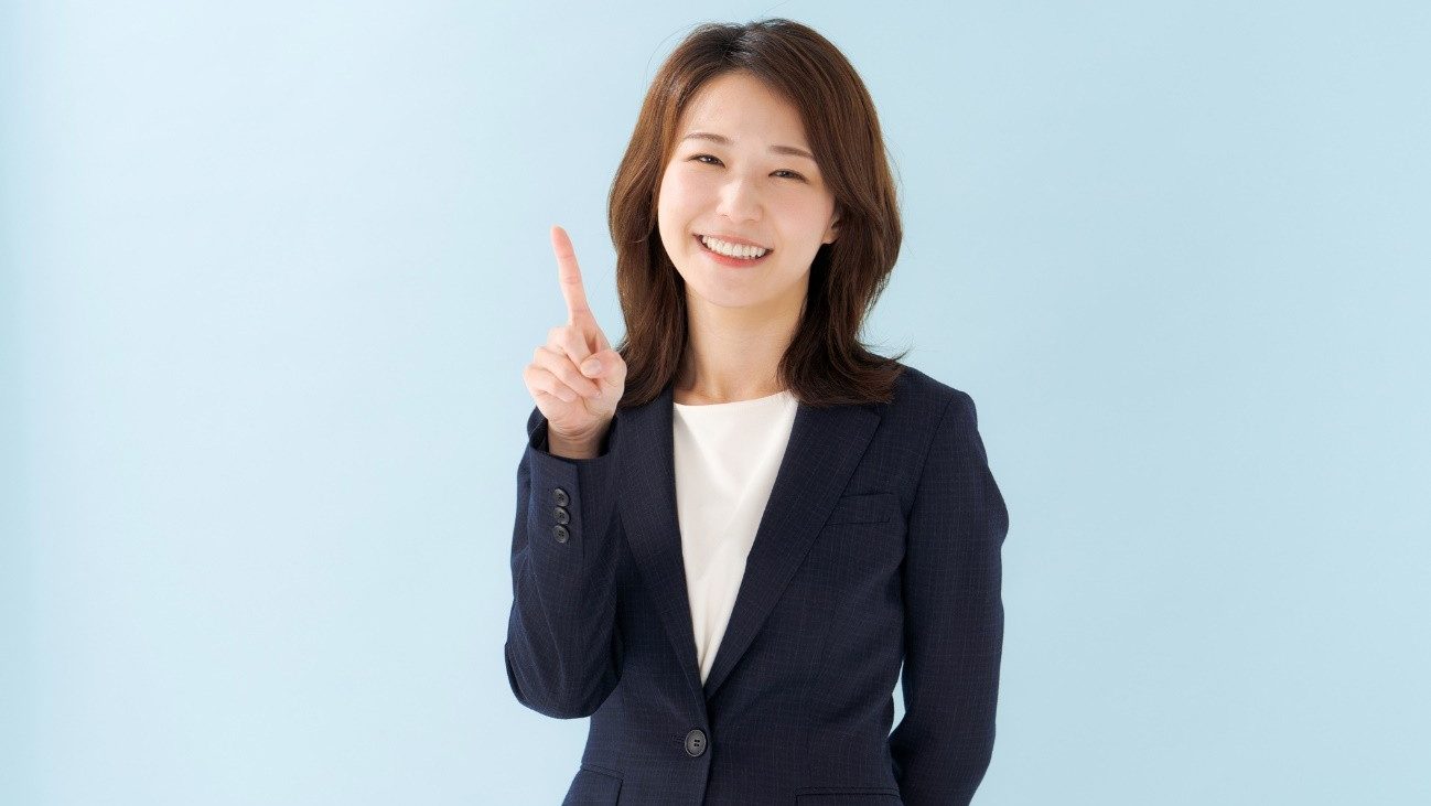 就労移行支援から就労継続支援へ移行することもできる。スーツを着た女性が微笑んでポイントを説明している写真。
