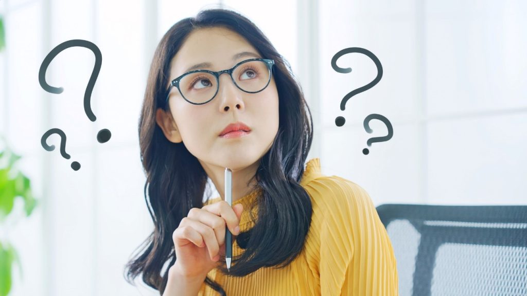 ボールペンをもって悩む女性の写真。就労移行支援中の収入源には何があるのでしょうか。経済的に頼れる制度や方法をしりましょう。