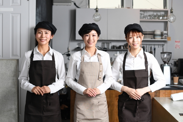 就労継続支援B型の仕事の例。エプロンを付けてカフェで働く女性3人の写真。事業所によって、飲食店での調理や、製菓の仕事がある。