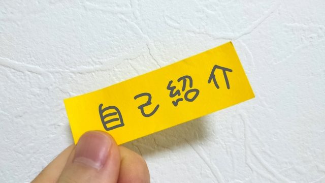 「自己紹介」と書かれた黄色のインデックスをつまんで差し出している写真。履歴書では自己紹介、自己PR、志望動機を入れて作成しましょう。
