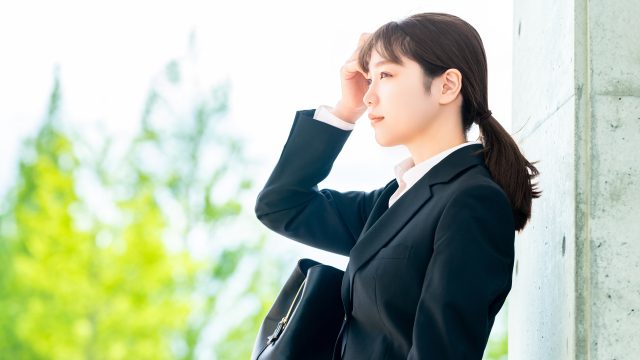 就職活動をするスーツを着た女性の写真。自分で就職活動をする。