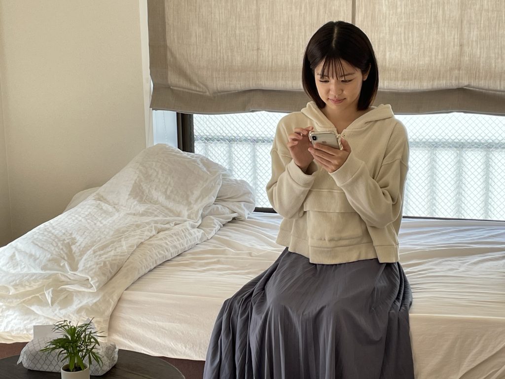 アクセスジョブのホームページをスマホで見る女性。就労移行支援アクセスジョブのホームページモデルさん。