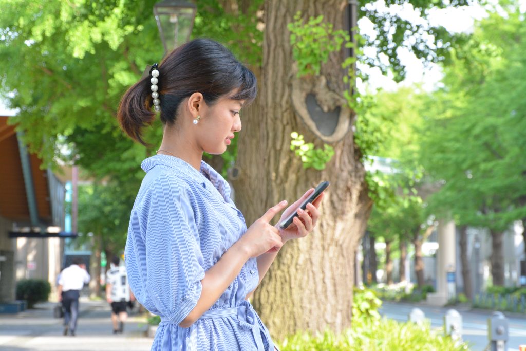 路上でスマホを片手に道を検索する女性の写真。就労移行支援事業所の選び方がポイント。自宅から通いやすい事も大切。