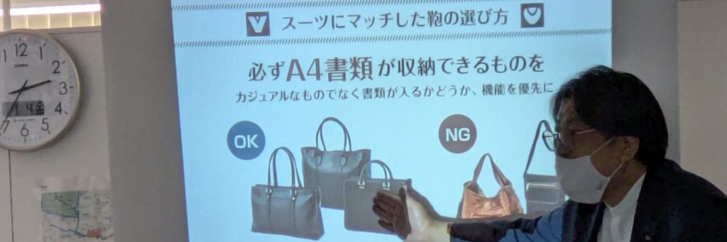 スーツの着こなし講座の様子。鞄の選び方について。必ずA4書類が収納できるものを選ぶ。