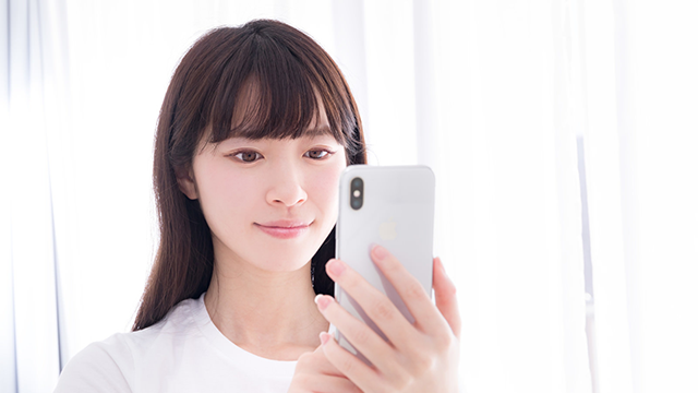 スマホを持つ女性の写真。就労移行支援の利用を検討している方は、まずは気になる事業所に見学や問い合わせすることをおすすめします。