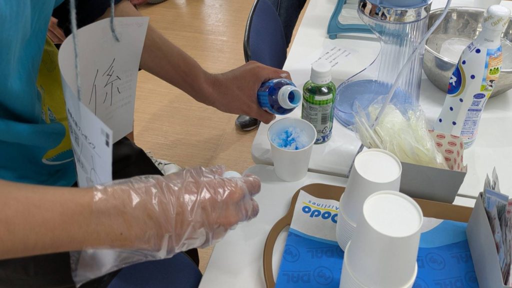 利用者さんがブルーハワイのかき氷を作っている様子。