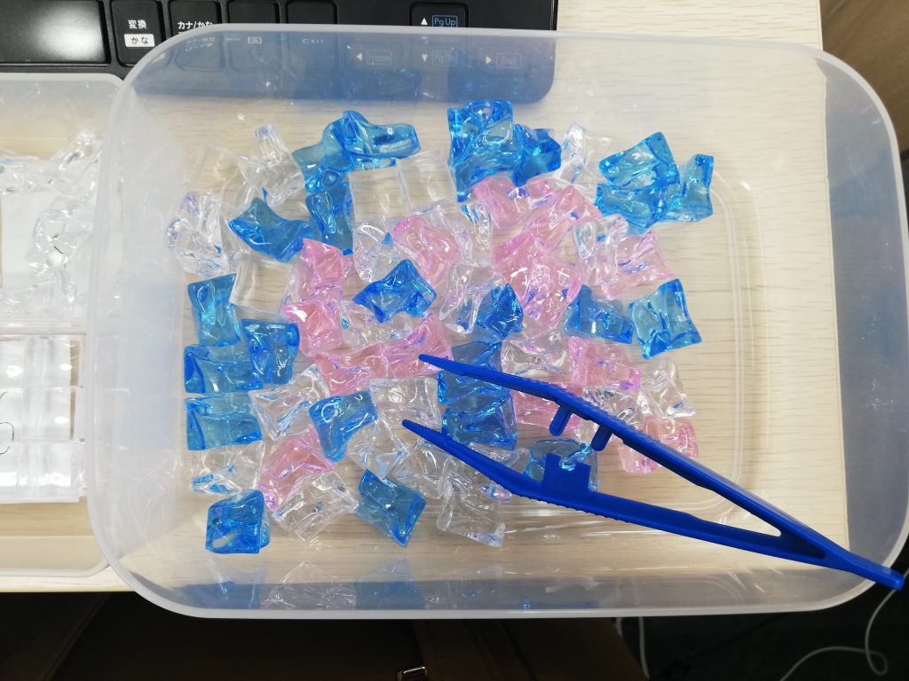 プラスチックのブロックをピンセットでつまみます。