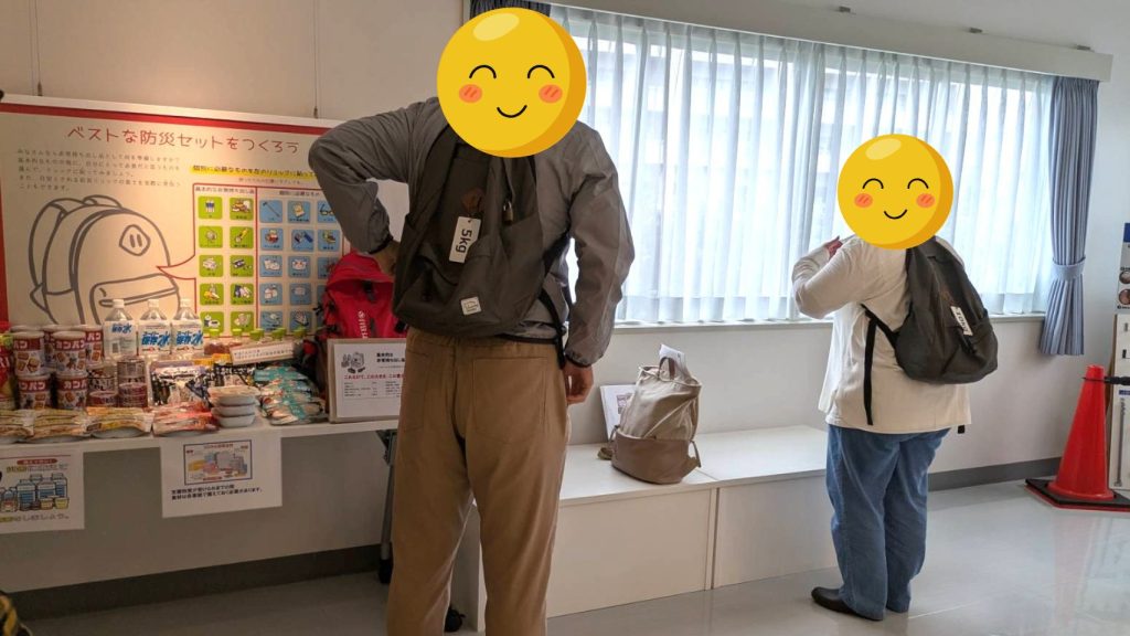 防災リュックの重さを体験する様子