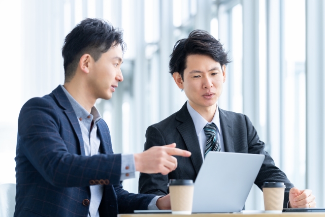 話をする2人の会社員の画像