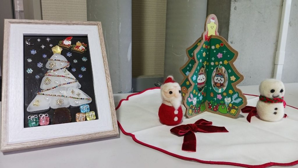 額縁に入ったツリーと羊毛フェルトで作られたサンタクロースと雪だるま