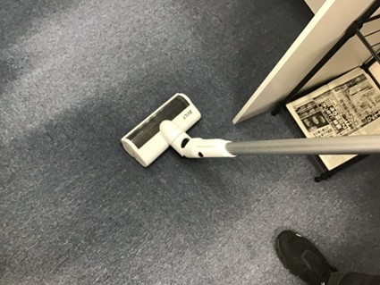 掃除の時間に床に掃除機をかけている様子。