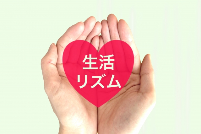 生活リズムと書かれたハートを手にする女性の手の画像