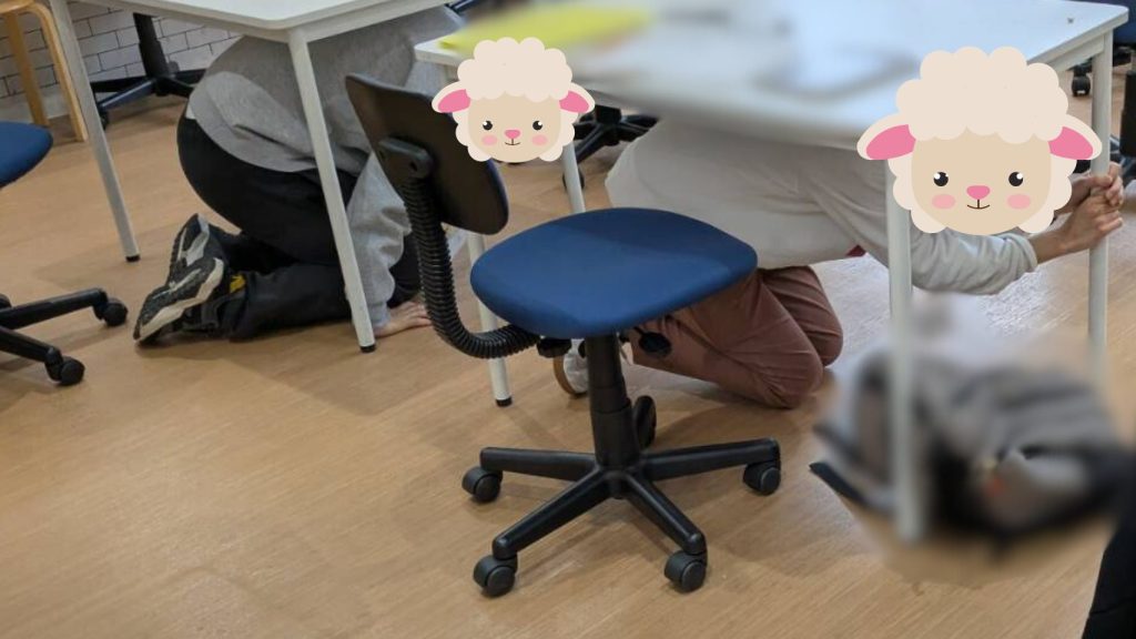 地震を想定した避難訓練で、机の下に入る利用者さんの様子