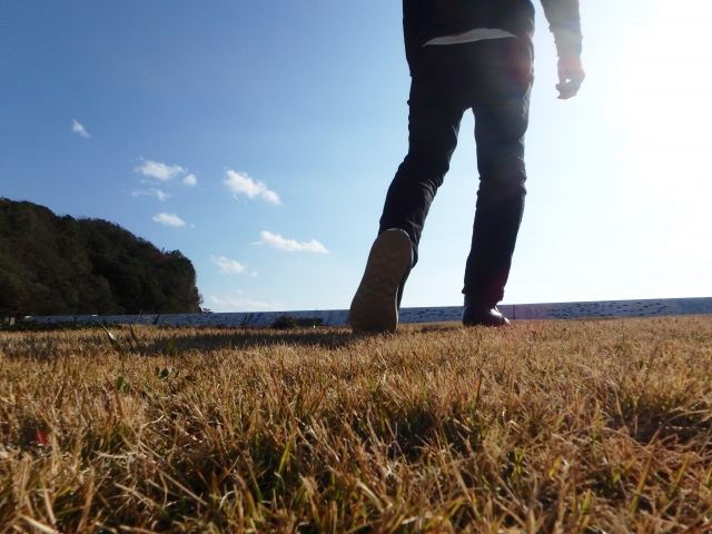 光に向かって歩き出す男性の画像