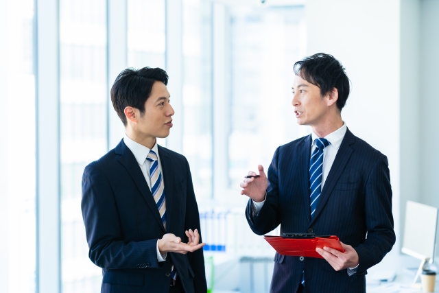相談をする二人の男性の画像